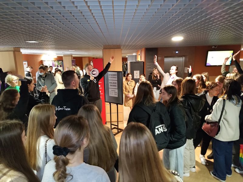 Drzwi Otwarte - EkSoc UŁ 19.04.2023 - Student z megafonem zaprasza tłum do udziału w spacerze po Wydziale