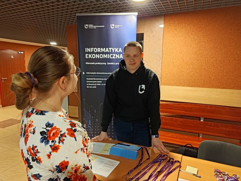 Drzwi Otwarte - EkSoc UŁ 19.04.2023 - Student na stoisku kierunku Informatyka Ekonomiczna odpowiada na pytania uczennicy